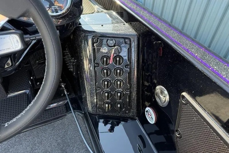 Slide: The Image of Control panel of 2026 Phoenix 920 Elite X boat with steering wheel and switches. - 7