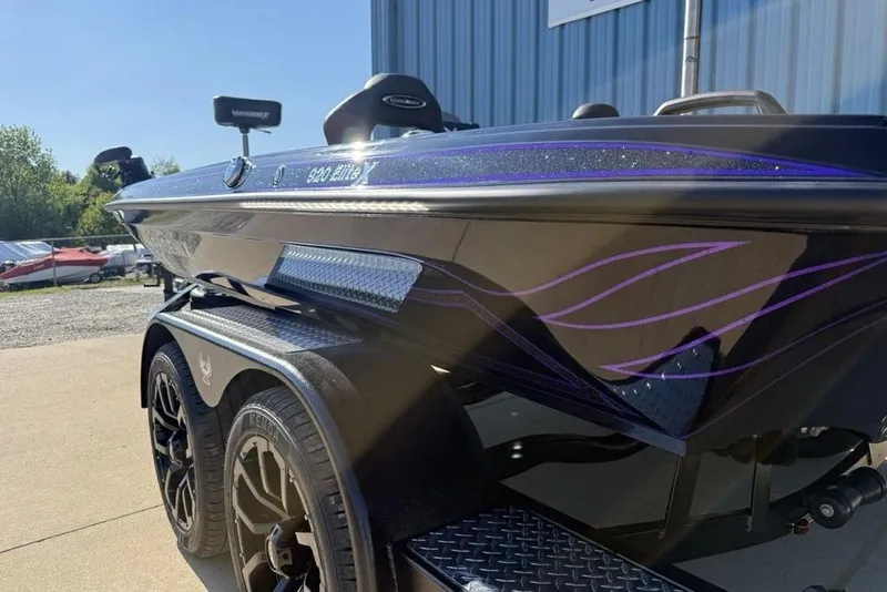 Slide: The Image of 2026 Phoenix 920 Elite X boat with sleek design and purple accents, parked outdoors. - 8