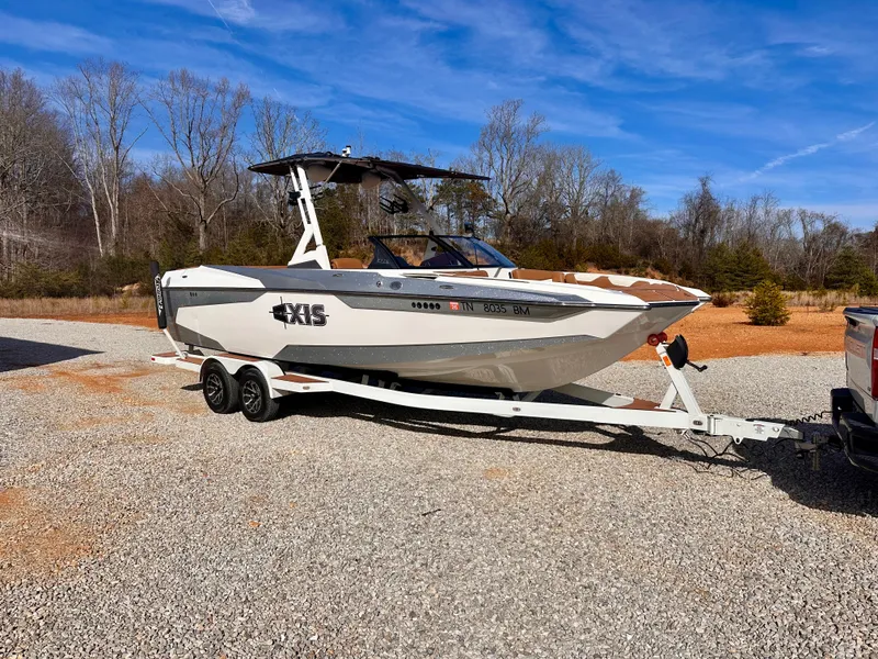 Slide: The Image of 2023 Axis Wake Research A24 boat on trailer outdoors. - 2