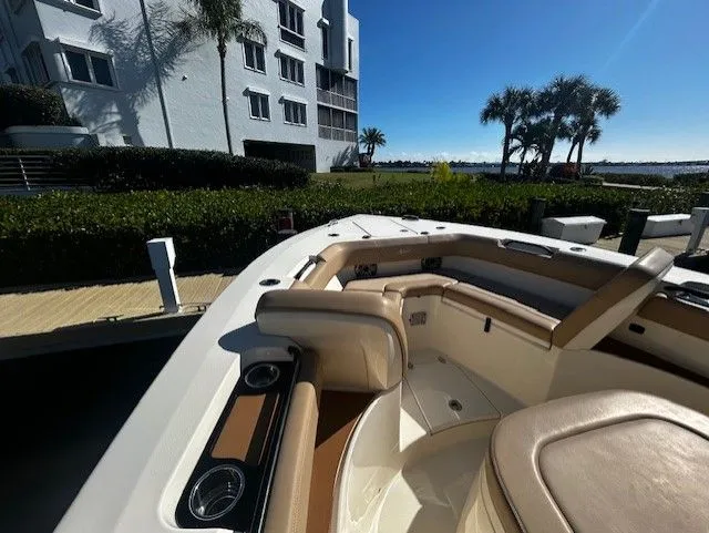 Slide: The Image of 2022 Scout 305 LXF boat docked with palm trees in the background. - 25