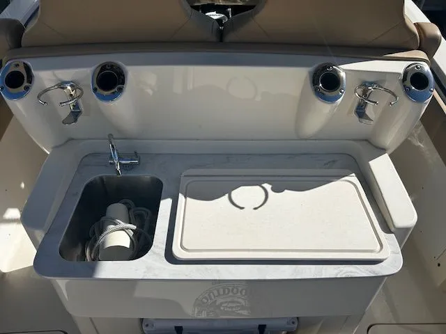 Slide: The Image of Scout 305 LXF 2022 boat kitchenette with sink and fishing rod holders. - 38