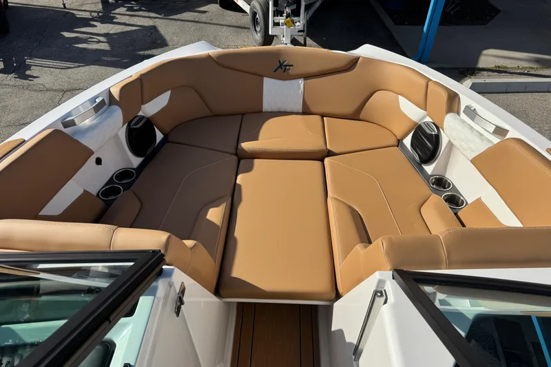 Slide: The Image of 2026 MasterCraft XT24 boat interior with tan leather seating and cup holders. - 13