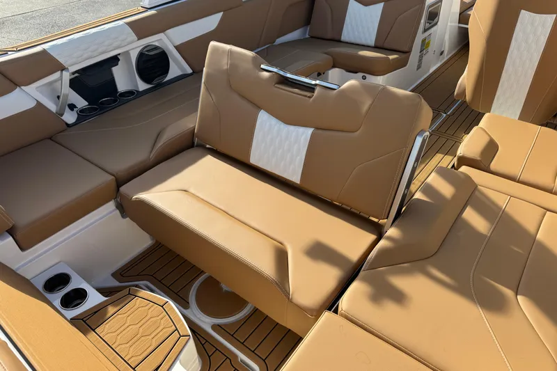 Slide: The Image of 2026 MasterCraft XT24 boat interior with tan and white seating, cup holders, and stylish design. - 16