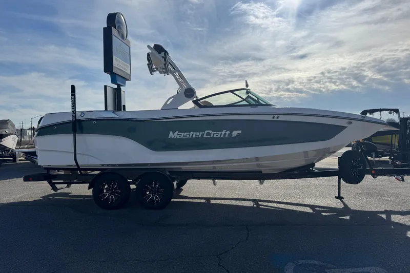 Slide: The Image of 2026 MasterCraft XT24 boat on trailer under a cloudy sky. - 5