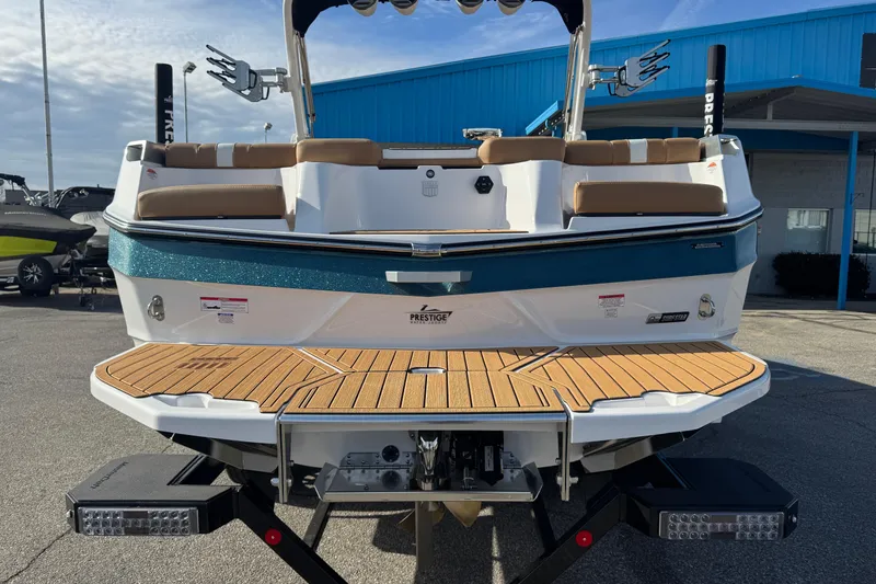 Slide: The Image of 2026 MasterCraft XT24 boat with teak deck and cushioned seating, displayed outdoors. - 7