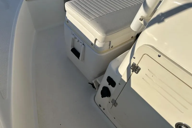 Slide: The Image of 2015 Boston Whaler 170 Montauk interior with cushioned seating and storage compartment. - 14