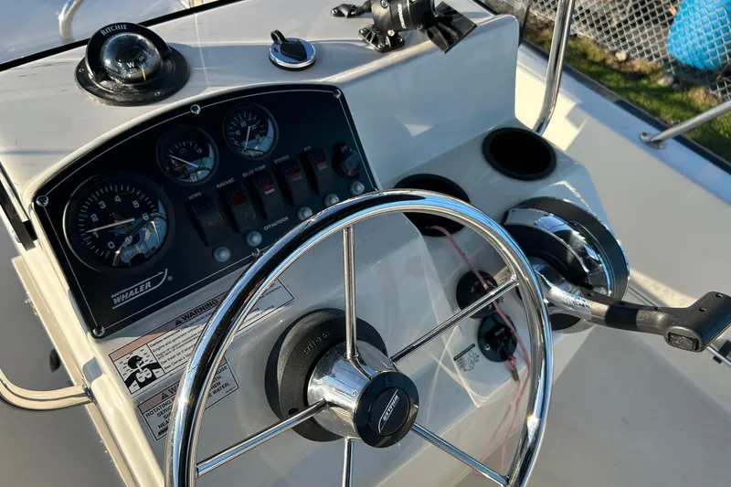 Slide: The Image of Steering console of a 2015 Boston Whaler 170 Montauk boat with gauges and controls. - 22