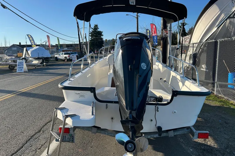 Slide: The Image of 2015 Boston Whaler 170 Montauk boat with outboard motor, parked on a trailer. - 6