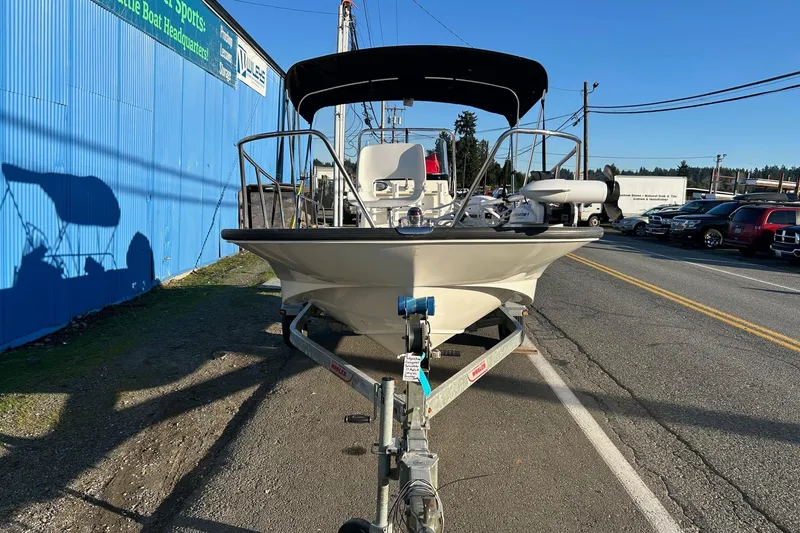 Slide: The Image of 2015 Boston Whaler 170 Montauk boat on trailer, parked beside a blue building. - 8