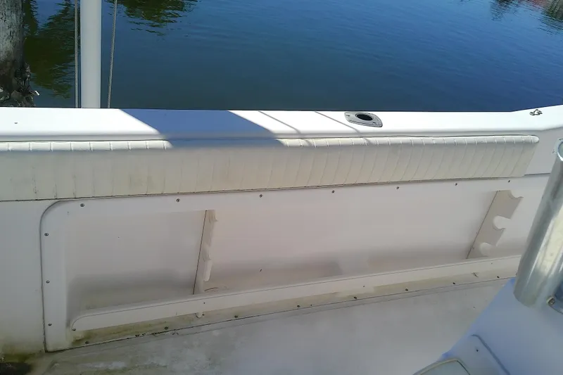 Slide: The Image of 1999 Grady-White Escape 209 boat interior with white seating and rod holders. - 13