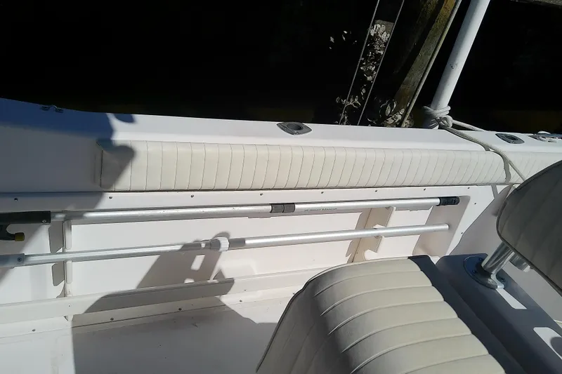 Slide: The Image of 1999 Grady-White Escape 209 boat interior with white cushioned seating and rod holders. - 14