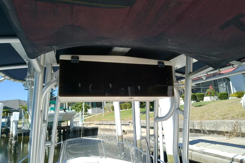 Slide: The Image of 1999 Grady-White Escape 209 boat with overhead console and canopy, docked near waterfront homes. - 18