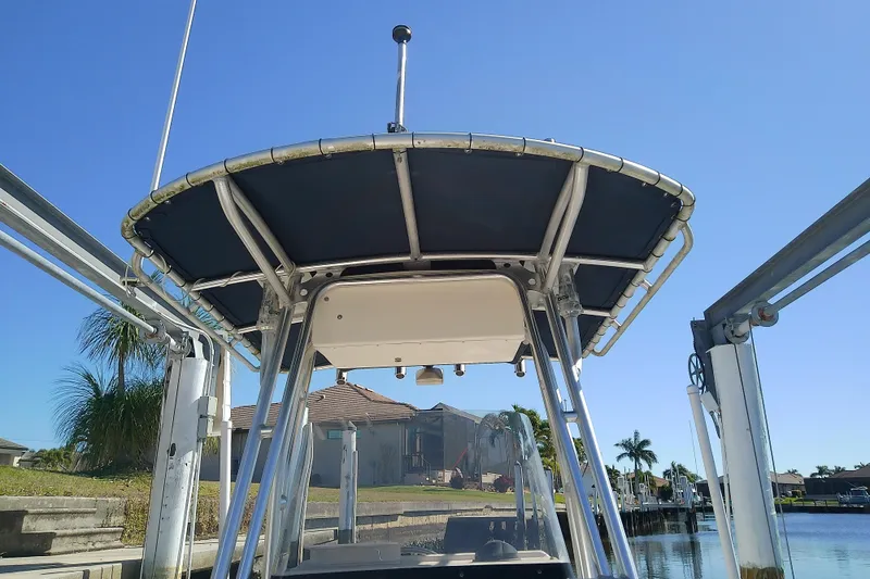 Slide: The Image of 1999 Grady-White Escape 209 boat with T-top, docked near waterfront homes. - 21