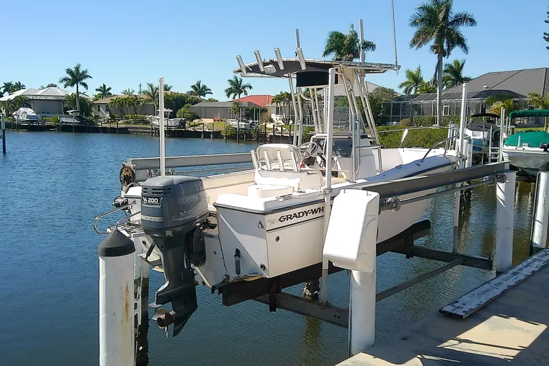 Slide: The Image of 1999 Grady-White Escape 209 boat docked by waterfront homes with palm trees. - 3