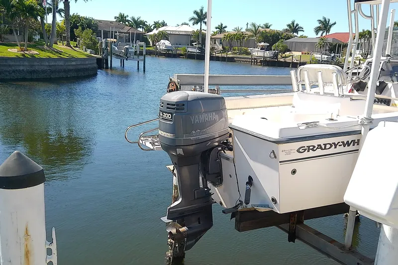 Slide: The Image of 1999 Grady-White Escape 209 boat with Yamaha outboard motor docked in a scenic canal. - 4