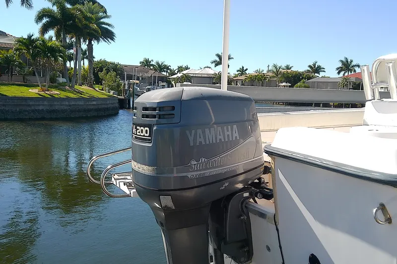 Slide: The Image of 1999 Grady-White Escape 209 boat with Yamaha V6 200 outboard motor, docked by palm trees. - 5
