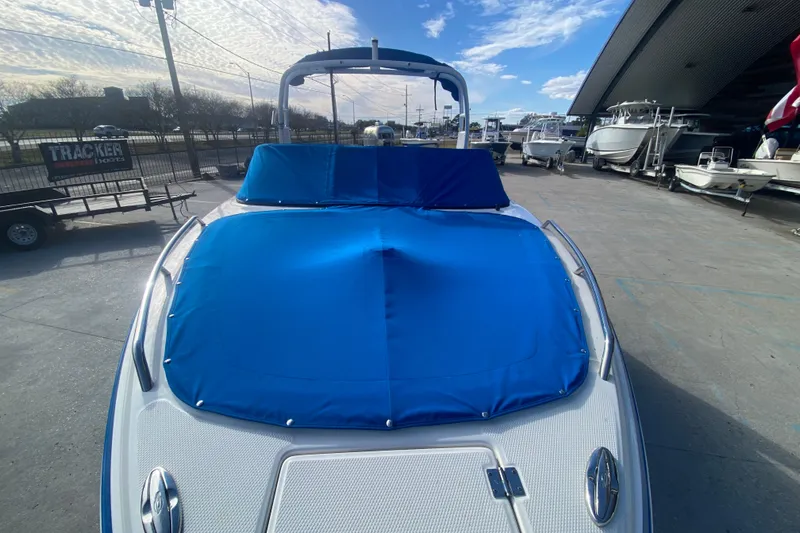 Slide: The Image of 2017 Chaparral 227 SSX boat with blue cover, parked outdoors under a clear sky. - 12