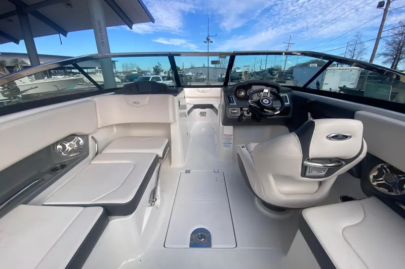 Slide: The Image of 2017 Chaparral 227 SSX boat interior with seating and steering wheel under a blue sky. - 16