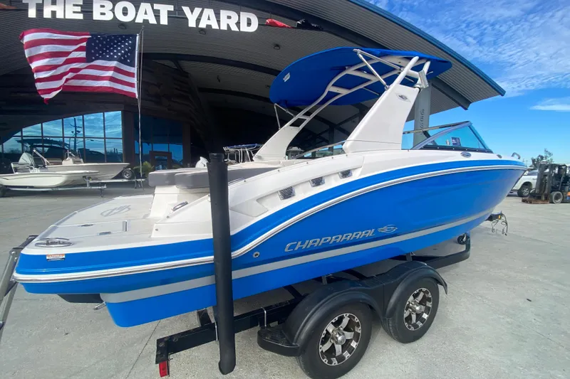 Slide: The Image of 2017 Chaparral 227 SSX boat in blue, displayed at The Boat Yard with American flag. - 2