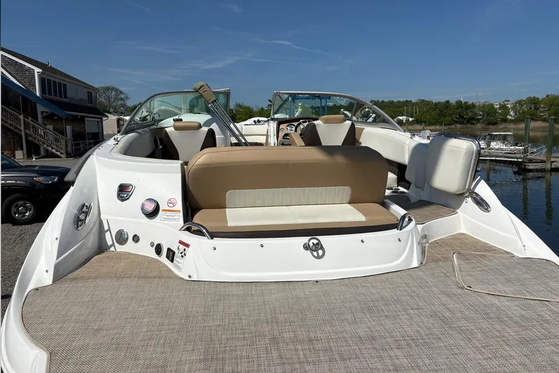 Slide: The Image of 2015 Cruisers Sport Series 258 Bow Rider boat with beige seating, docked near waterfront. - 8