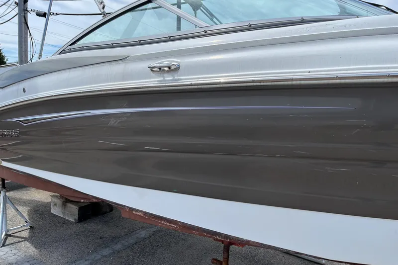Slide: The Image of 2015 Cruisers Sport Series 258 Bow Rider boat side view, docked on land. - 9
