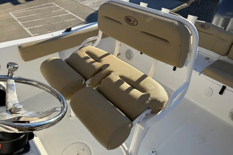 Slide: The Image of 2018 Sea Hunt Ultra 225 boat interior with beige seating and steering wheel. - 19