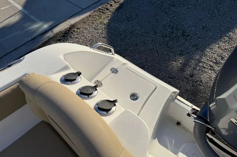 Slide: The Image of 2018 Sea Hunt Ultra 225 boat interior with beige seating and deck features. - 21