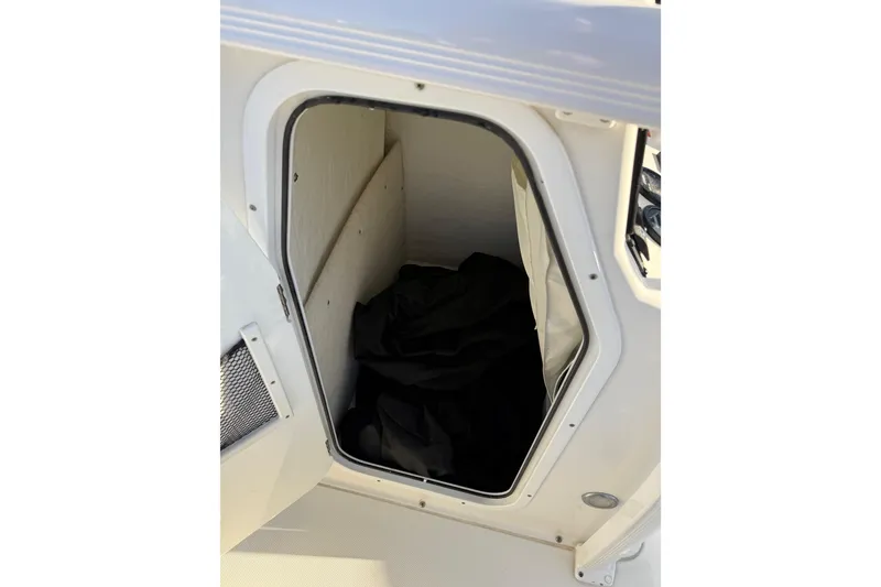 Slide: The Image of Storage compartment on a 2018 Sea Hunt Ultra 225 boat, open with black cover inside. - 25