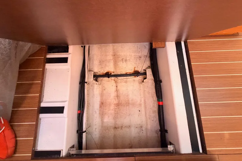 Slide: The Image of Bilge compartment of 2014 Jeanneau Sun Odyssey 469 sailboat, showing wiring and wooden flooring. - 104