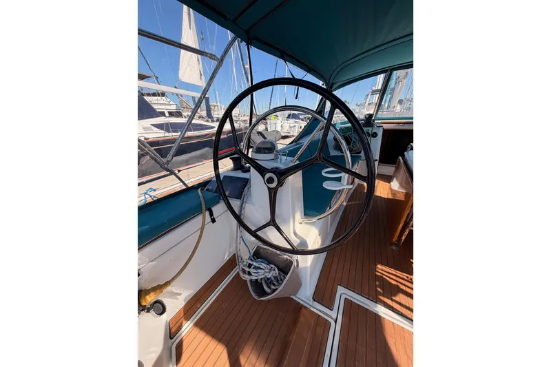 Slide: The Image of 2014 Jeanneau Sun Odyssey 469 sailboat cockpit with steering wheel and wooden deck. - 35