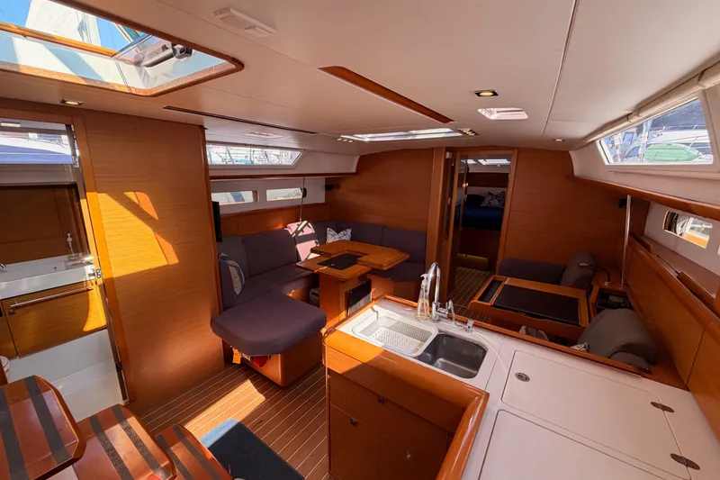 Slide: The Image of Interior of 2014 Jeanneau Sun Odyssey 469 sailboat, featuring modern wood finishes and spacious seating. - 57