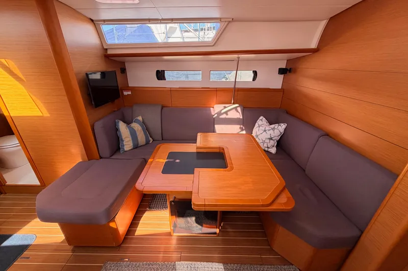 Slide: The Image of 2014 Jeanneau Sun Odyssey 469 interior with cozy seating and wooden table. - 67