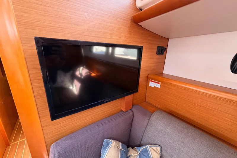 Slide: The Image of Interior of 2014 Jeanneau Sun Odyssey 469 with wall-mounted TV and cozy seating area. - 69