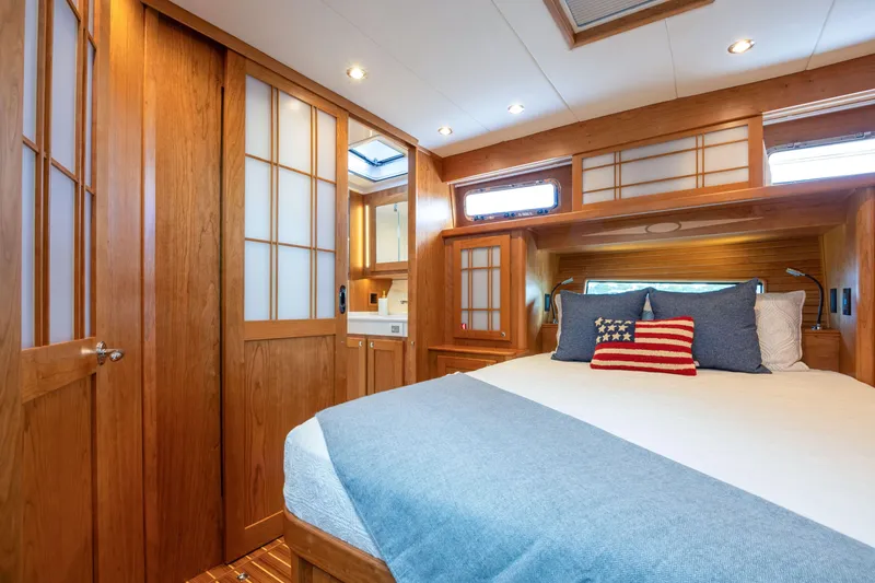 Slide: The Image of Luxurious 2027 Sabre 51 Salon Express cabin with elegant wood finishes and cozy bedding. - 26