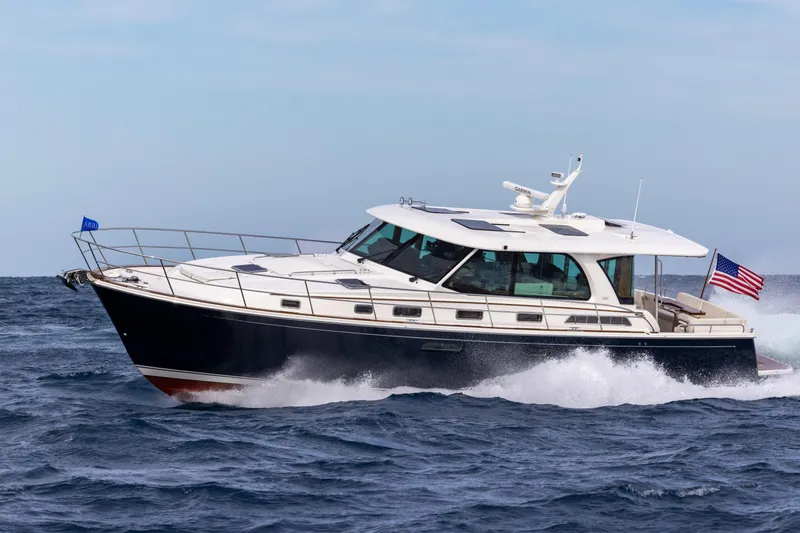 Slide: The Image of 2026 Sabre 51 Salon Express yacht cruising on open water with American flag. - 4