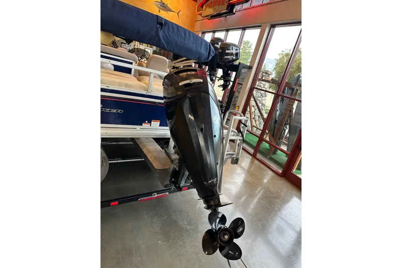 Slide: The Image of 2015 Sun Tracker Fishin' Barge 22 DLX with Mercury outboard motor in showroom. - 5