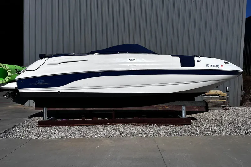 The Image of 2005 Chaparral Sunesta 254 boat on display outside a metal building. - 0