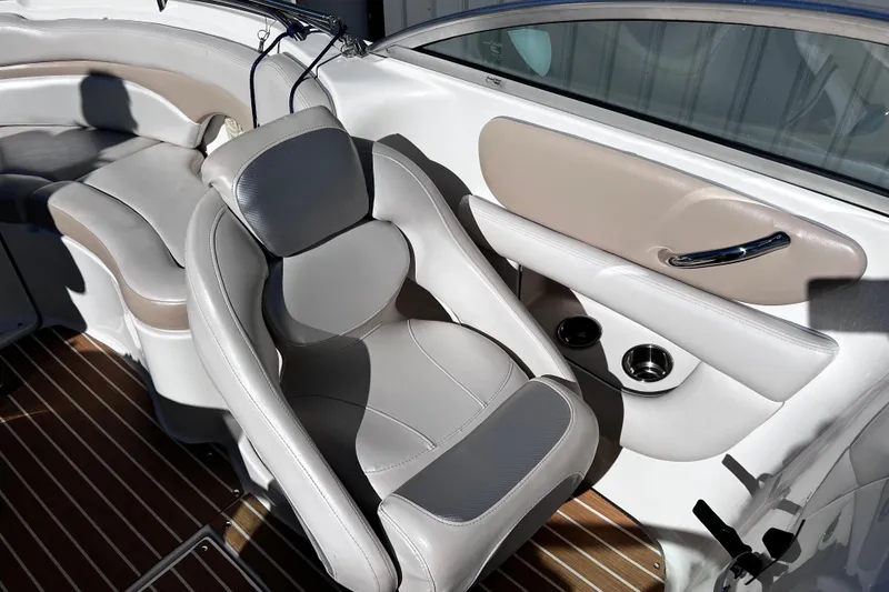 Slide: The Image of 2005 Chaparral Sunesta 254 boat interior with beige and gray seating, wood flooring. - 12