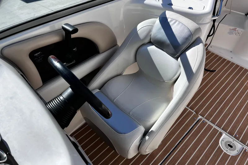 Slide: The Image of 2005 Chaparral Sunesta 254 boat interior with steering wheel and cushioned seat. - 17