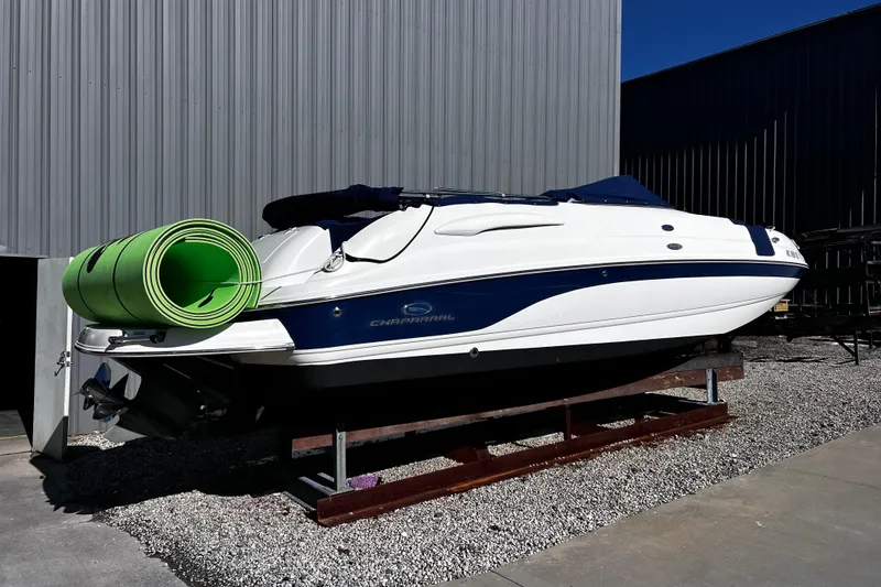 Slide: The Image of 2005 Chaparral Sunesta 254 boat on stand with green mat, outdoor storage. - 3