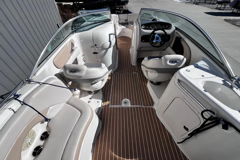 Slide: The Image of 2005 Chaparral Sunesta 254 boat interior with seating and steering wheel, featuring wood-style flooring. - 8