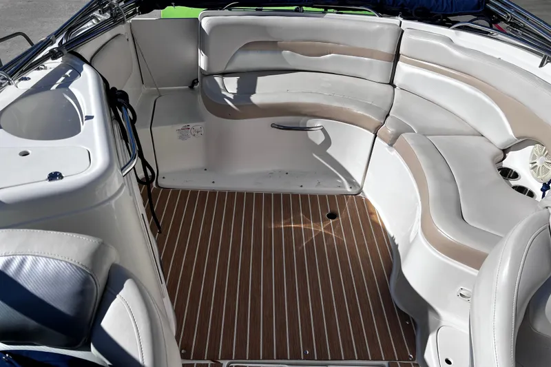 Slide: The Image of 2005 Chaparral Sunesta 254 boat interior with white seating and wood-patterned flooring. - 9