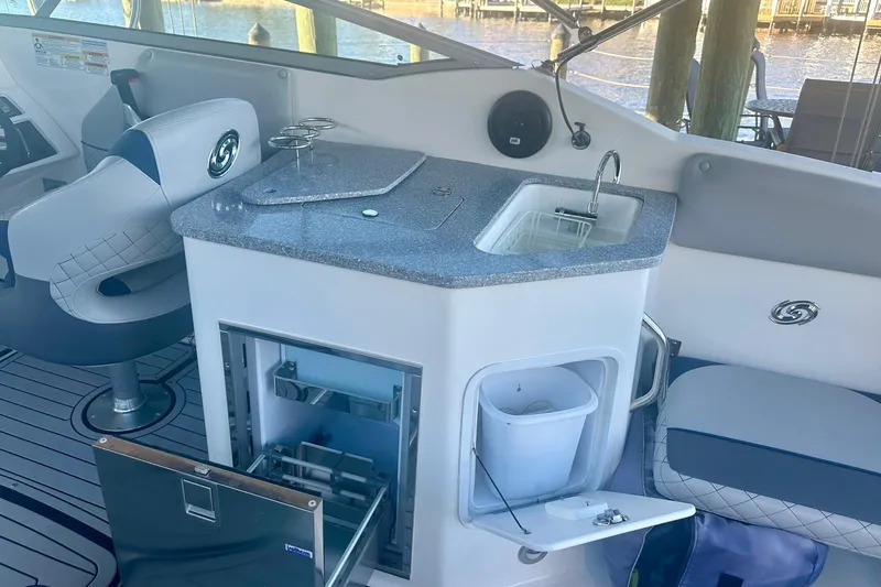 Slide: The Image of 2019 Hurricane SunDeck 2690 OB boat interior with sink, seating, and storage compartments. - 5