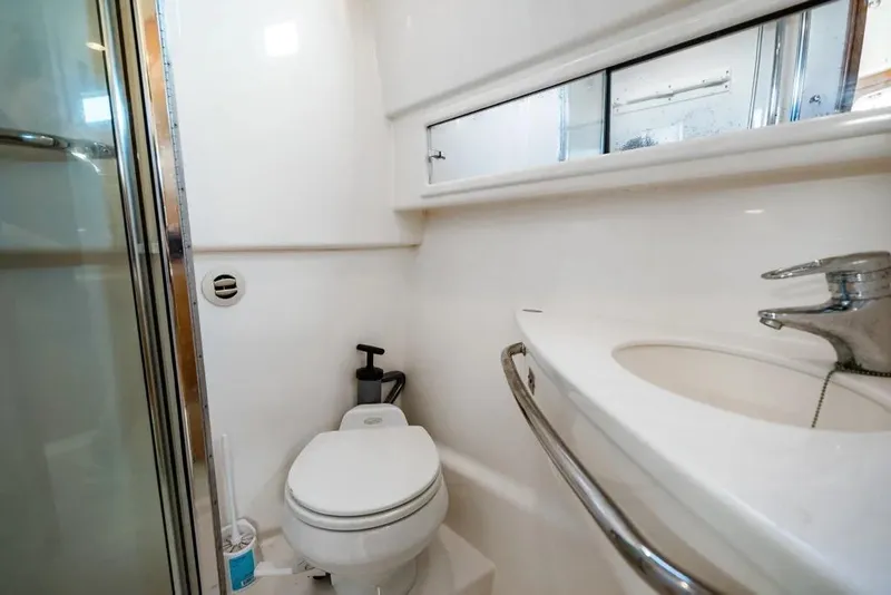 Slide: The Image of 2005 Cabo 35 Express yacht bathroom with toilet, sink, and shower. - 21
