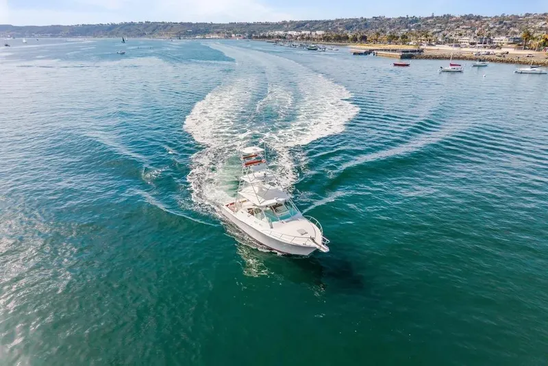 Slide: The Image of 2005 Cabo 35 Express yacht cruising in open water near coastline. - 24