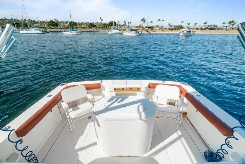 Slide: The Image of 2005 Cabo 35 Express boat deck with ocean view and anchored sailboats. - 28