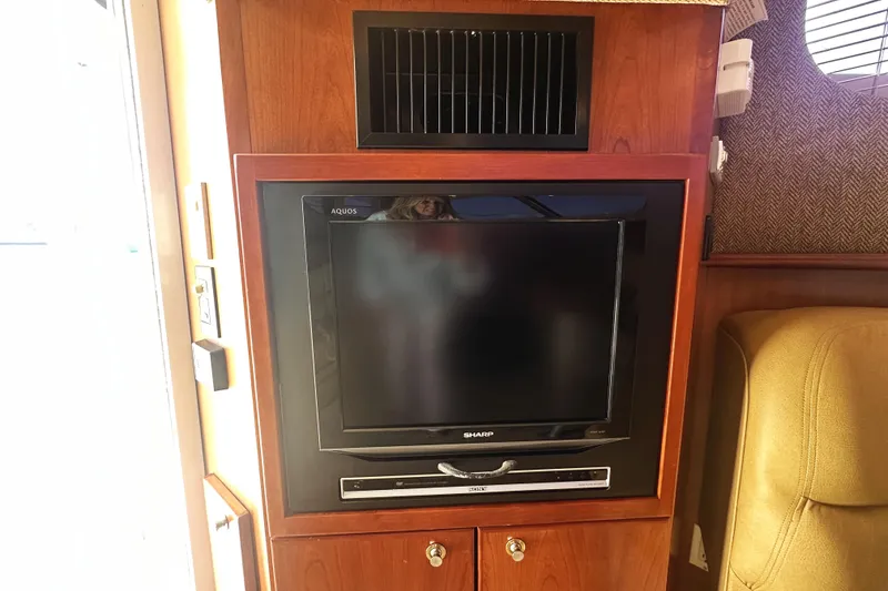 Slide: The Image of 2008 Silverton 36 Convertible interior with built-in Sharp TV and wooden cabinetry. - 16
