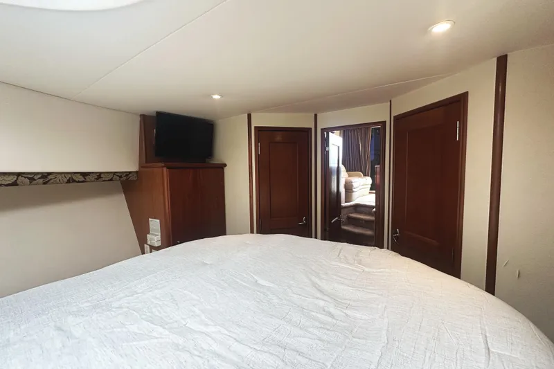 Slide: The Image of Interior of 2008 Silverton 36 Convertible yacht bedroom with TV and wooden doors. - 19