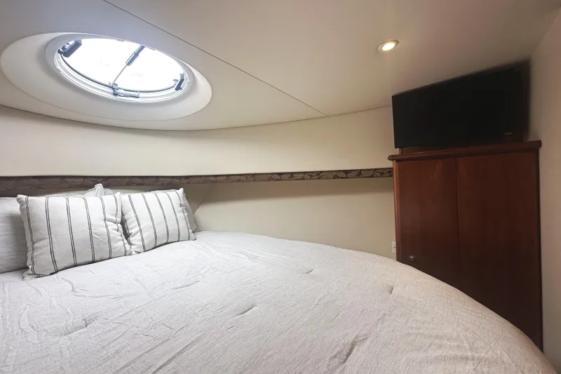 Slide: The Image of Cozy bedroom in 2008 Silverton 36 Convertible yacht with porthole and TV. - 23