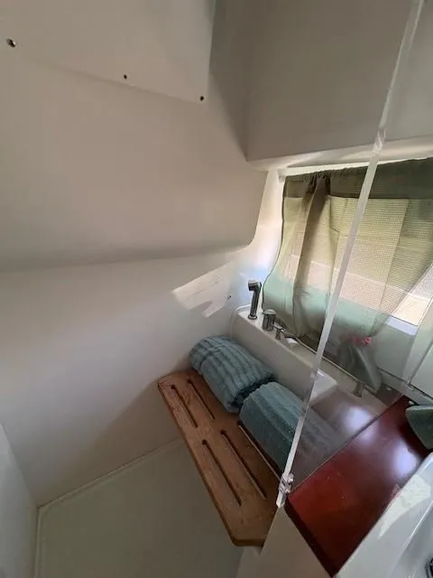 Slide: The Image of 2013 Jeanneau NC11 cabin interior with bed, window, and wooden accents. - 14